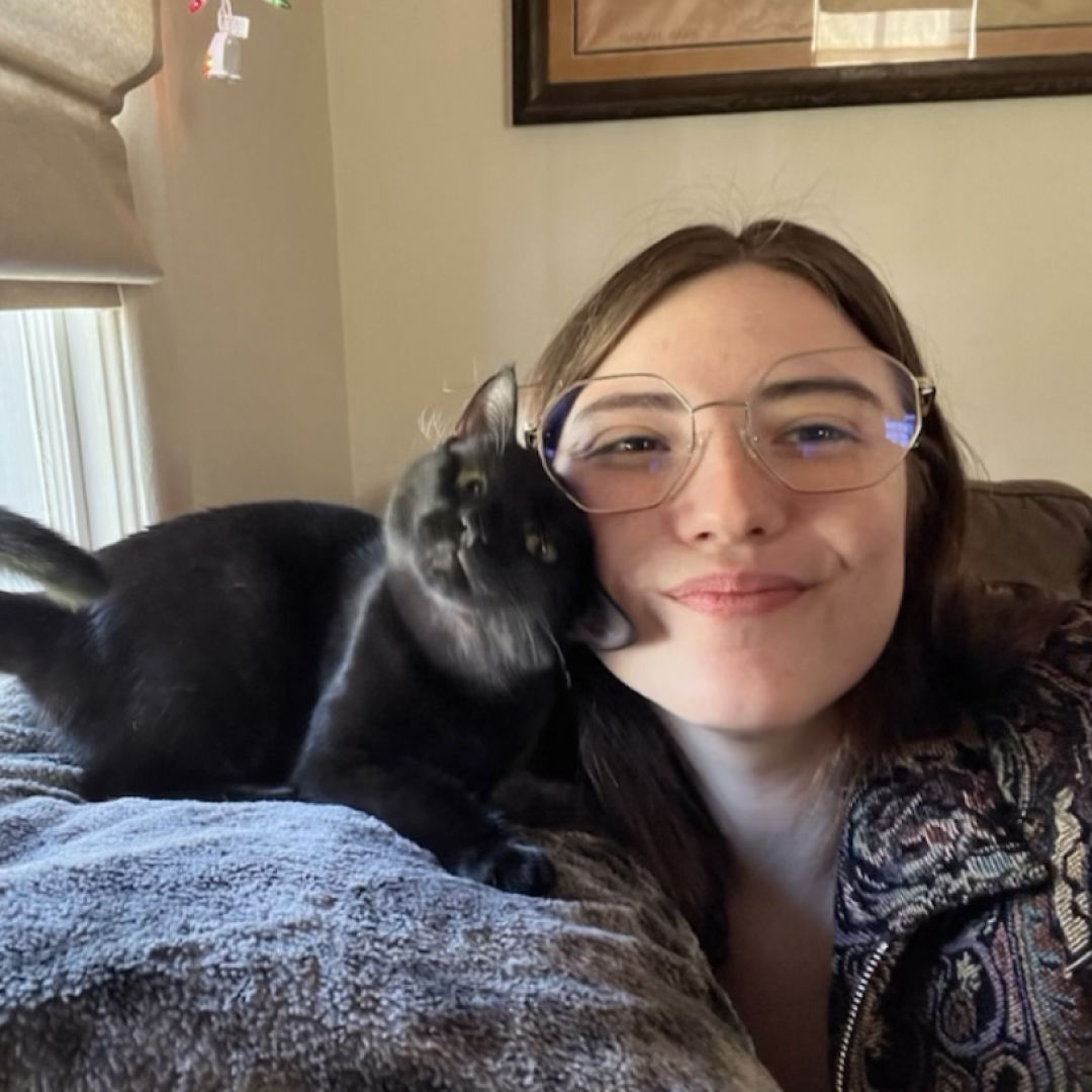 Woman snuggling with black cat