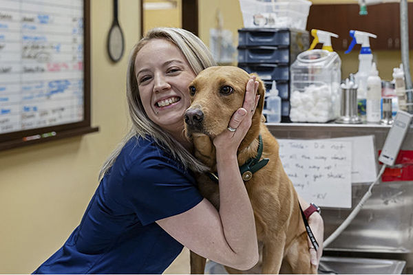 Vet staff hugging dog