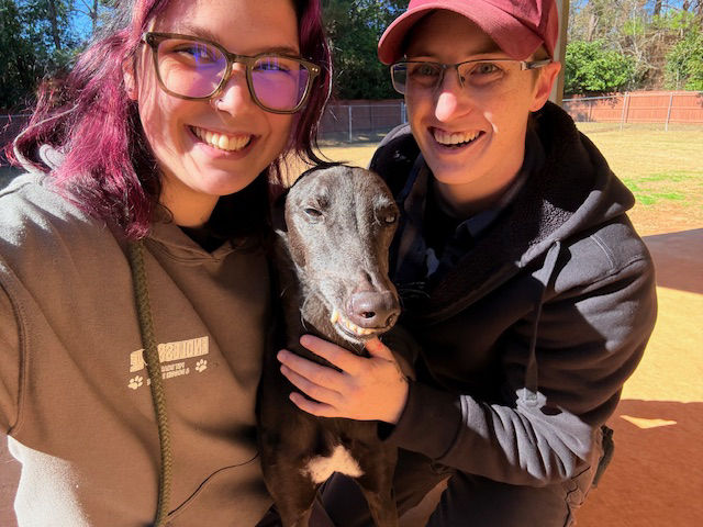 Endless Love Pet Palace staff smiling with dog.