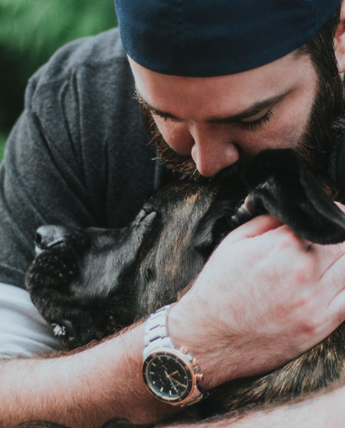 man kissing and hugging a big dog