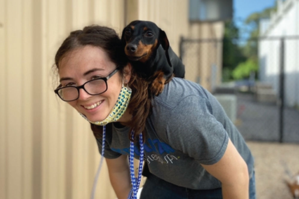 Weiner dog sitting on woman's back